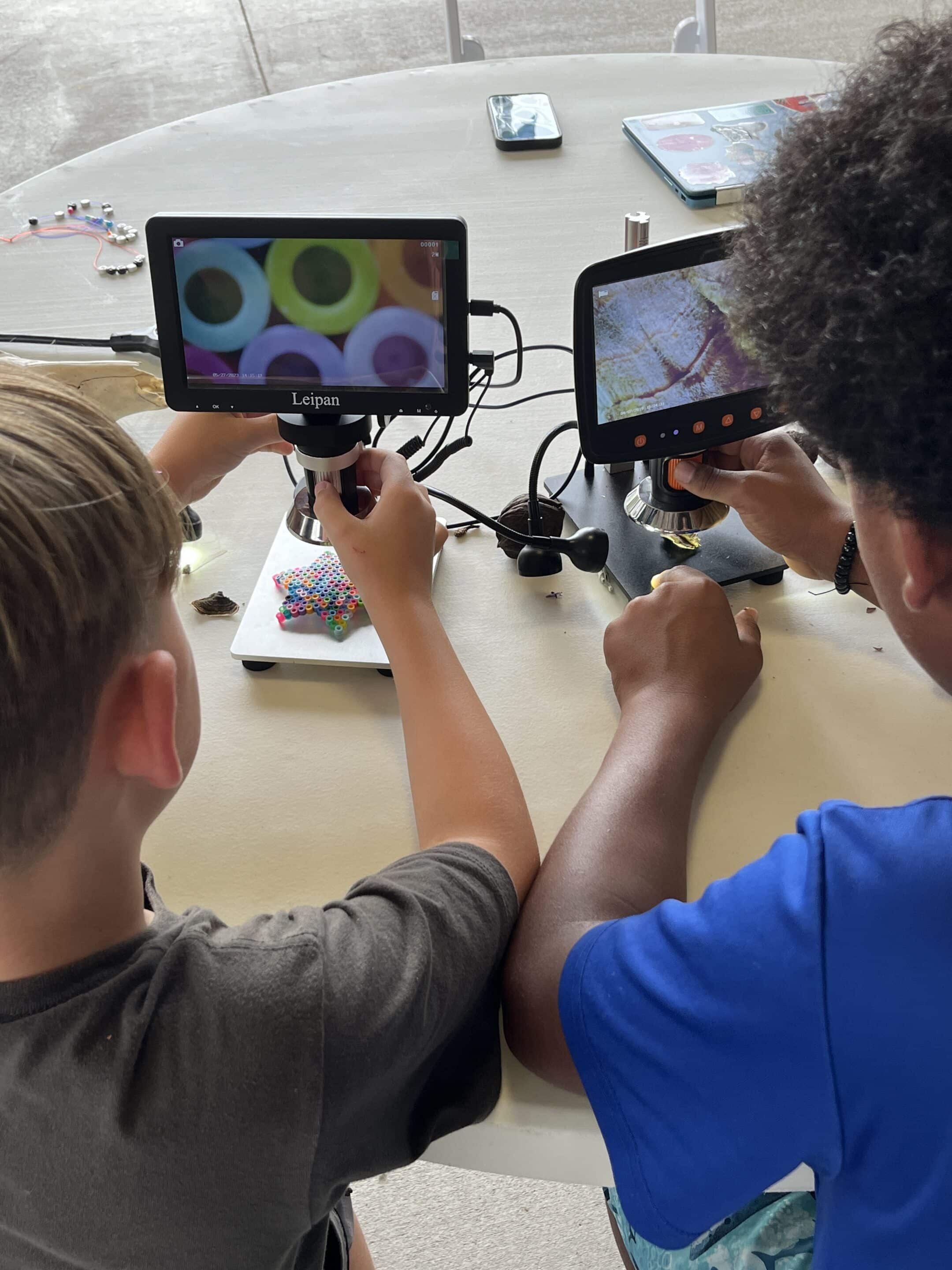 Boys playing with a microscope at Windwood